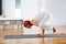 Yoga Crow Pose in wooden floor gym