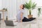 Yoga exercise concept, Asian woman doing yoga with lying in cobra pose and watching tutorial online
