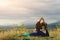Yoga exercise outdoors. Young woman sits in yoga pose on rock. Freedom, calmness and relax, woman happiness. Toned image. Lifestyl