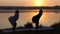 Yoga Exercises of Two Young Women at a Splendid Sunset Mear a Picturesque Lake