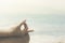 Yoga gesture of the hands of a woman facing the ocean