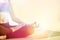 Yoga girl meditating indoor and making a zen symbol with her hand. Closeup of woman body in yoga pose