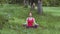 Yoga girl performing meditation breathing technique sitting in a lotus position exercises outdoors in the park or garden