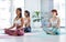 Yoga heals the soul. A group of sporty young women meditating while exercising in a yoga studio.