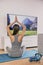 Yoga at home fitness class streaming on TV app online woman training in living room on exercise mat meditating alone - workout