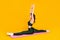 Yoga house training lady sit mat stretch split legs twine raise arms up wear sports suit isolated yellow color