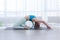 Yoga Indoor. Sports recreation. Beautiful young woman with dreadlocks in asana with yoga ring in room with big panoramic