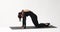 A yoga instructor performs a variation of the Marjariasana exercise, a cat pose with an up and down bend