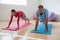 Yoga instructor with student exercising in club