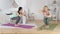 Yoga instructor and young woman performing exercise with extended arms