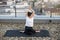 Yoga lover practicing seated asana with twisted arms on roof