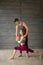 Yoga male teacher correcting female student performing Warrior Pose in studio