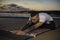 Yoga man practicing on the beach at sunset