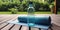 A yoga mat and a water bottle on a wooden floor, with a peaceful garden in the background, concept of Serenity, created