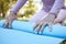 Yoga mat, woman hands and exercise outdoor ready to start fitness with blurred background. Zen exercise, meditation and