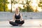 Yoga and Meditation in Modern City Caucasian Woman Relax Lotus Position Sitting Yoga Mat Outdoors Summer Park on Concrete floor