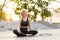 Yoga and Meditation in Modern City Caucasian Woman Relax Lotus Position Sitting Yoga Mat Outdoors Summer Park on Concrete floor