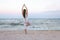Yoga meditation woman meditating at beach sunset relaxing in yoga posture, tree pose, vrksasana. Relaxed serene woman enjoying eve