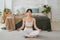 Yoga mindfulness meditation. Young healthy woman practicing yoga in living room at home. Woman sitting in lotus pose