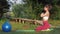 Yoga in nature, young attractive yogi girl meditating and doing yoga exercises on green grass among trees