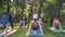 Yoga at park, group of mixed age women doing pose while sunset. slow motion