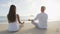 Yoga people meditating in lotus pose on beach