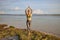 Yoga pose. Woman practicing yoga at the beach. Young woman standing and raising arms with namaste mudra. Bali