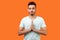 Yoga practice for mind balance. Portrait of peaceful handsome brunette man meditating. indoor studio shot isolated on orange