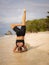 Yoga practice near the ocean. Caucasian woman practicing Salamba Shirshasana, Yoga Headstand is an inverted asana. Balancing asana