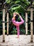 Yoga practice outdoor. Asian yoga teacher practicing yoga, standing in Natarajasana, Lord of the Dance Pose. Balancing, back