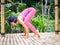 Yoga practice outdoor. Asian yoga teacher preparing for Bakasana, Crow pose. Balancing asana in hatha yoga. Yoga retreat. Bali,