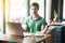 Yoga and relaxation time. Young calm businessman in green t-shirt sitting with laptop and try to focus on something on his work