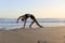 Yoga retreat. Beautiful asana. Slim woman practicing yoga on the beach. Stretching exercise. Flexible body. Copy space. Horizontal