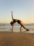 Yoga retreat. Beautiful asana. Slim woman practicing yoga on the beach. Stretching exercise. Flexible body. Copy space. Vertical