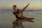 Yoga retreat. Body twist asana. Slim woman practicing yoga on the beach. Stretching exercise. Flexible body. Copy space.