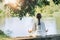 Yoga Retreat. Peaceful Young Woman Sitting in Lotus Position and Meditating by the Lake