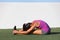 Yoga runner girl stretching back over legs doing seated Forward Bend. Fold named Paschimottanasana. Active woman doing
