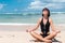 Yoga in the sea or ocean beach. Girl meditating in lotus pose on the tropical island Bali, Indonesia.. Healthy lifestyle