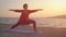 Yoga in the sea or ocean beach. Yoga meditation concept. Woman practicing yoga outdoors during sunset