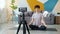 Yoga teacher recording video doing asanas meditating talking in modern apartment