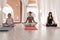 Yoga teachers sitting in the lotus position with their eyes closed.