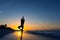 Yoga vrikshasana tree pose by woman in silhouette on the beach with sunset sky background. Free space for text.