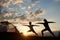 Yoga Warrior pose exercising by family couple at daybreak on background of morning sky with sparse clouds and bright sun