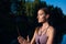 Yoga woman in meditate and breathe on a sunrise in nature. Smoke from aromatic stick in hands.