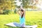 Yoga woman meditates on grass pose lotus in summer day