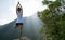 Yoga woman meditating on mountain peak cliff edge