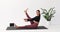 Yoga woman performs Paripurna Navasana exercise, boat pose with alternating leg lifts and foot warm-up