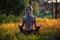 Yoga woman silhouette in Lotus pose on a picturesque glade in a forest.