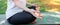 Yoga. A woman in sportswear meditates with her hands folded in her lap, sitting on a Mat, in a Park on the grass. Side view.