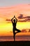 Yoga woman training in sunset in tree pose